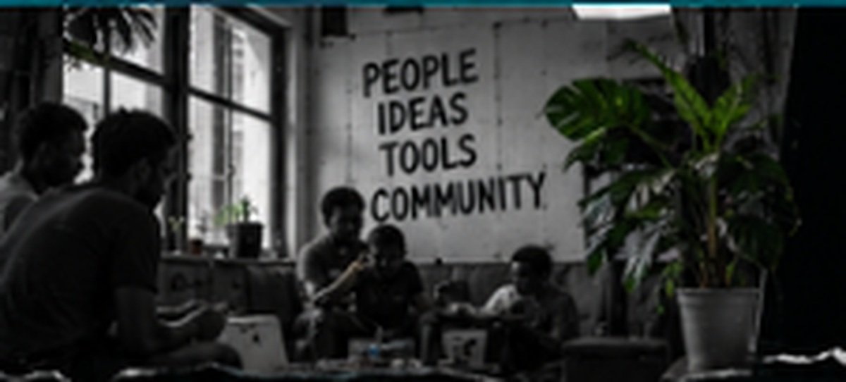 People sitting together at a table collaborating on a project in a community makerspace